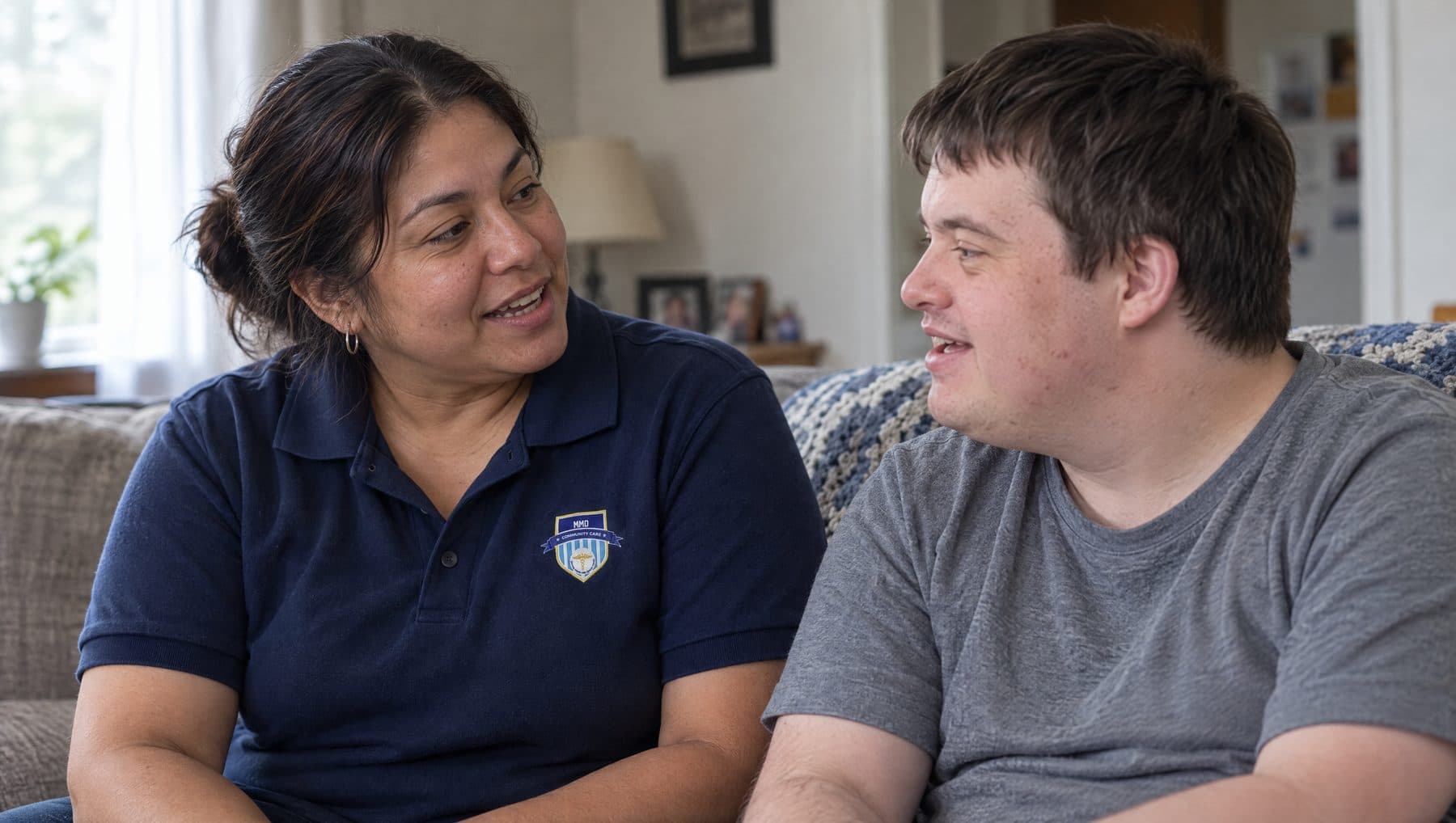 An MMD support worker talking with a client in his own living room
